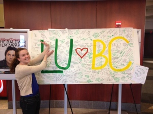 Lindsey Murphy, BC '14, smiles with the banner signed by triplet sister, Casey Murphy, LU '14